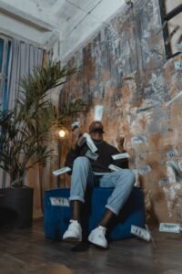 man sitting on blue chair throwing money in the air